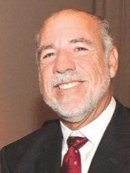 smiling older man with a white beard in a suit